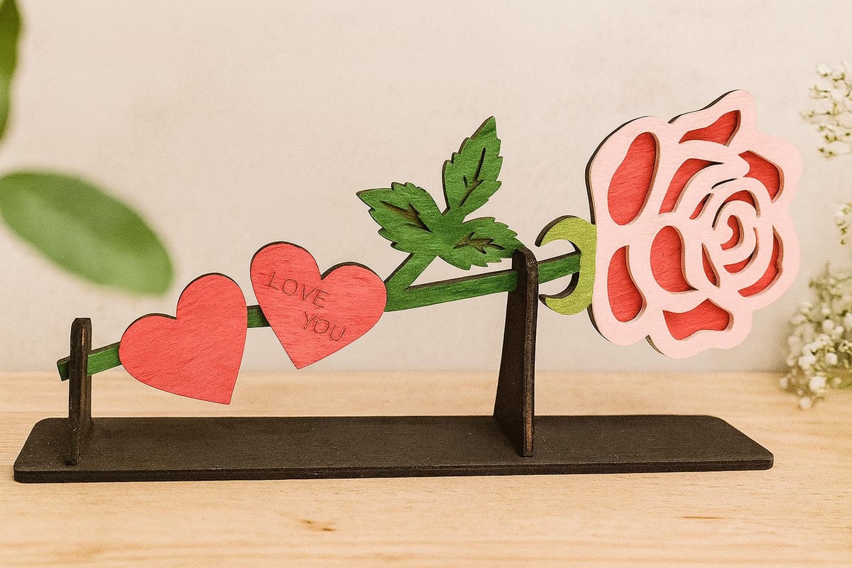 wooden rose rising from a personalized heart stand, shown in a styled setting